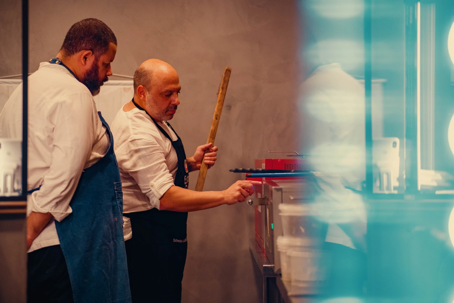 Diego Martins e Alexandre Xavier juntos diante do forno de pizza
