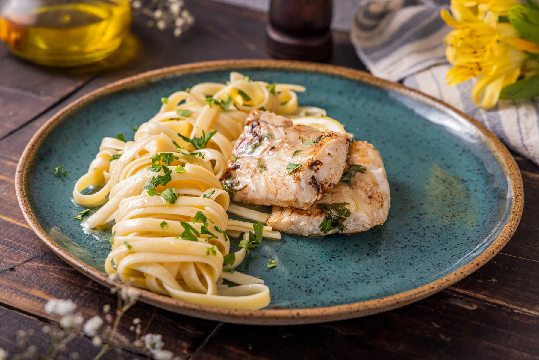 Filés de peixe com massa e ervas em prato azul