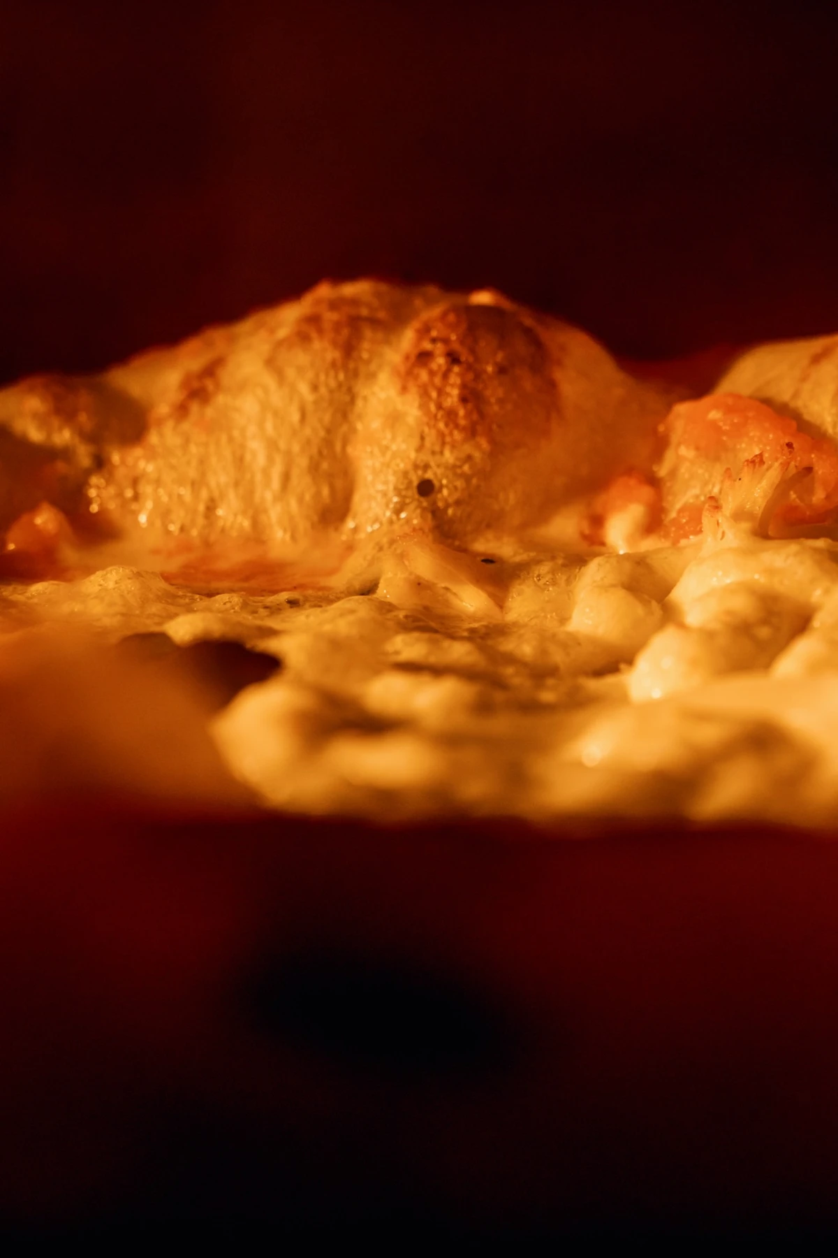 Borda da pizza crescendo e dourando no calor do forno